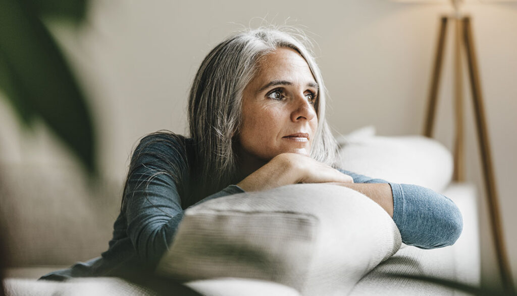 Pensive woman on the couch at home